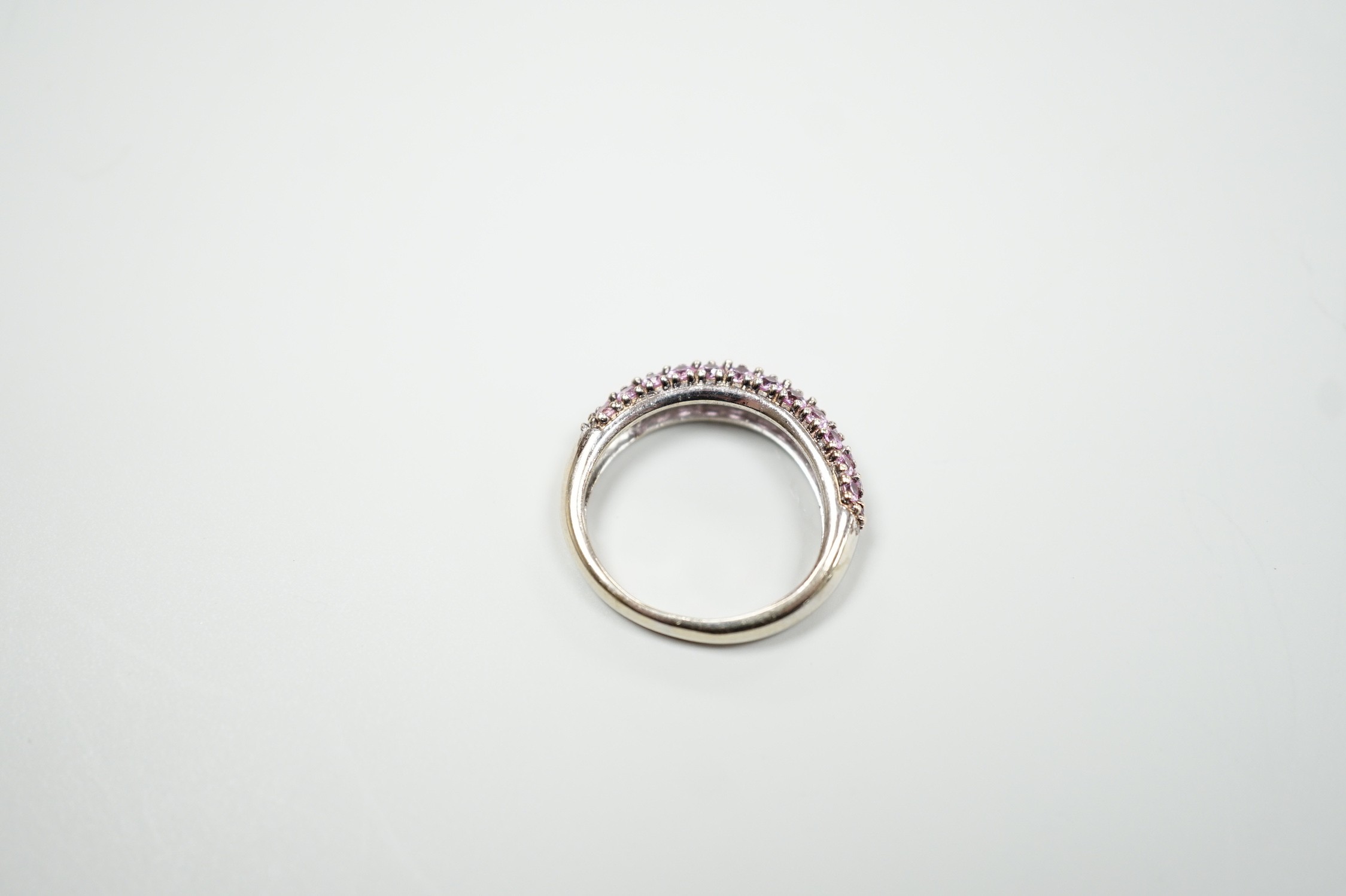 A modern 18ct white gold and pink stone cluster set half hoop ring, size J, gross weight 4.2 grams.